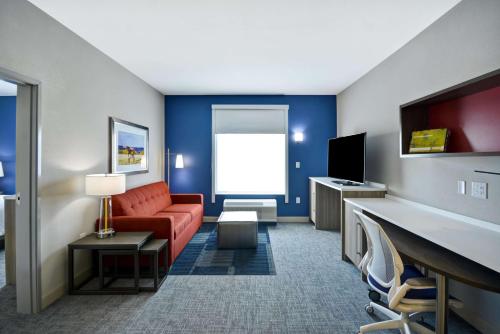 Camera d'albergo con divano e TV di Home2 Suites By Hilton Bloomington Normal a Normal