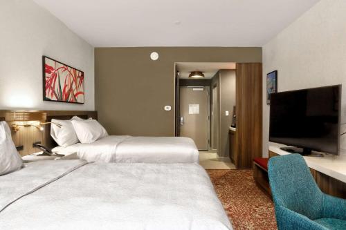 a hotel room with two beds and a flat screen tv at Hilton Garden Inn Bel Air, Md in Bel Air