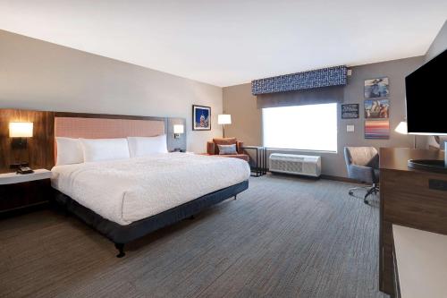 Cette chambre comprend un lit et une télévision à écran plat. dans l'établissement Hampton Inn Crown Point, In, à Crown Point