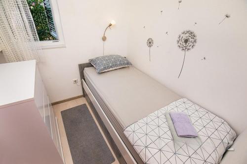 mały pokój z łóżkiem i oknem w obiekcie Apartmani Maestral Fabijanić w mieście Pag