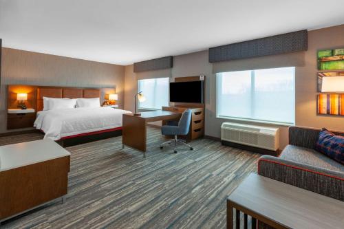 Bloomfield HillsにあるHampton Inn & Suites Bloomfield Hills Detroitのベッドとデスクが備わるホテルルームです。