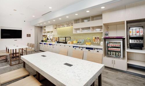 a large kitchen with a table and a refrigerator at Home2 Suites By Hilton Johnson City, Tn in Johnson City