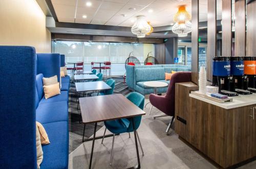 a restaurant with blue chairs and tables and a counter at Tru By Hilton Niceville, Fl in Niceville