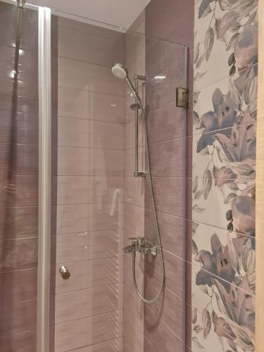 y baño con ducha y papel pintado con motivos florales. en Apartament modern-nou Cristina&Jessica, en Mediaş