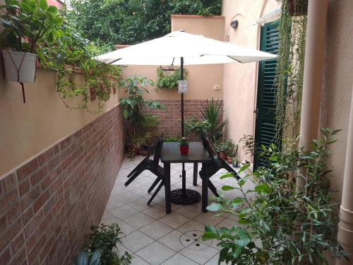 une terrasse avec une table et un parasol dans l'établissement IL PICCOLO EDEN - Private Garden, à Livourne