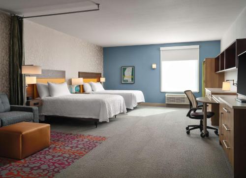 um quarto de hotel com duas camas e uma secretária em Home2 Suites By Hilton Tupelo em Tupelo