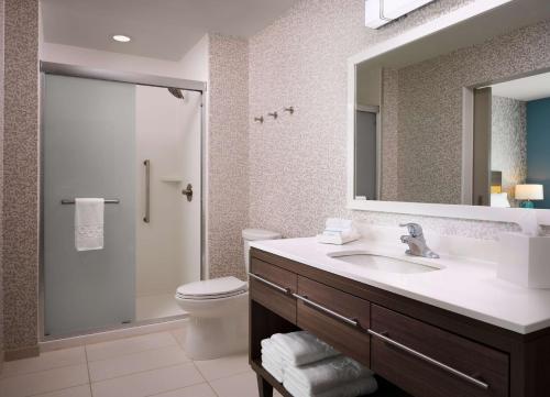 a bathroom with a sink and a toilet and a mirror at Home2 Suites By Hilton Tupelo in Tupelo