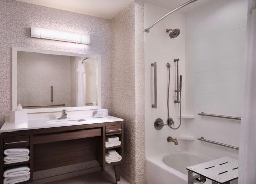 图珀洛Home2 Suites By Hilton Tupelo的带水槽、浴缸和镜子的浴室