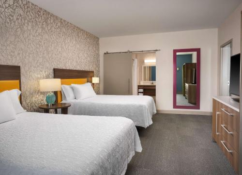 a hotel room with two beds and a television at Home2 Suites By Hilton Tupelo in Tupelo