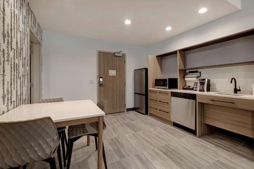 a kitchen with a table and chairs in a room at Home2 Suites By Hilton Blythewood, Sc in Blythewood