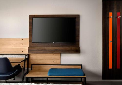 a living room with a tv and a chair at Tru By Hilton Tupelo, Ms in Tupelo