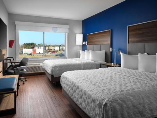 ein Hotelzimmer mit 2 Betten und einem Fenster in der Unterkunft Tru By Hilton Tupelo, Ms in Tupelo