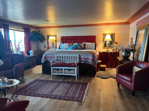 a bedroom with a large bed with a red headboard at Mermaid's Muse Bed and Breakfast in Brookings