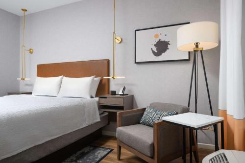 a bedroom with a bed and a chair and a lamp at Hampton Inn & Suites Huntsville Downtown, Al in Huntsville