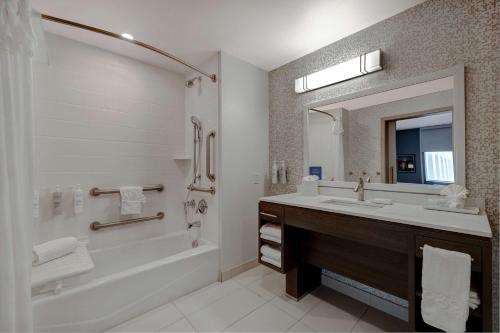a bathroom with a sink and a tub and a mirror at Home2 Suites By Hilton Las Vegas Northwest in Las Vegas