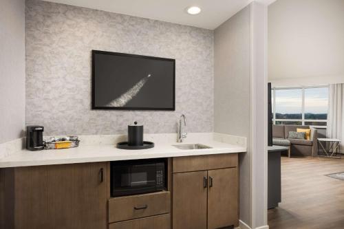 a kitchen with a sink and a tv on the wall at Hampton Inn & Suites Huntsville Downtown, Al in Huntsville