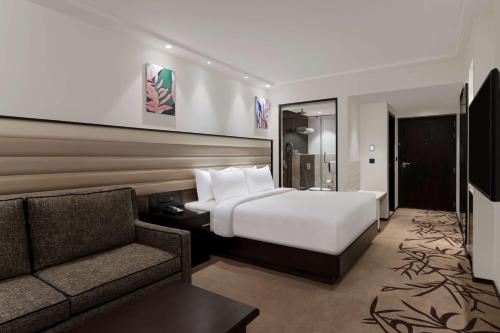 a hotel room with a bed and a couch at Hilton Garden Inn Pune Hinjawadi in Pune