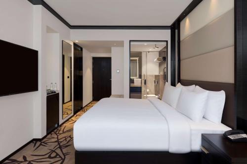 a bedroom with a large white bed and a television at Hilton Garden Inn Pune Hinjawadi in Pune