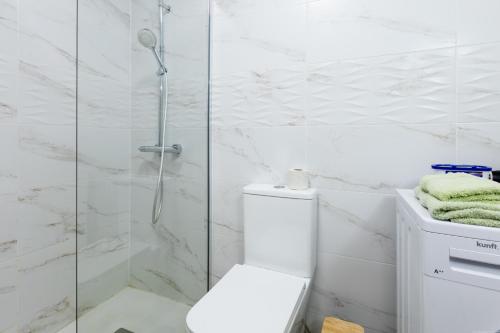 アデへにあるStudio in San Eugenioの白いバスルーム(シャワー、トイレ付)