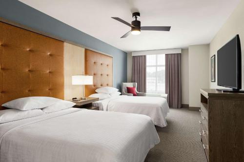 a hotel room with two beds and a flat screen tv at Homewood Suites By Hilton Carlisle in Carlisle