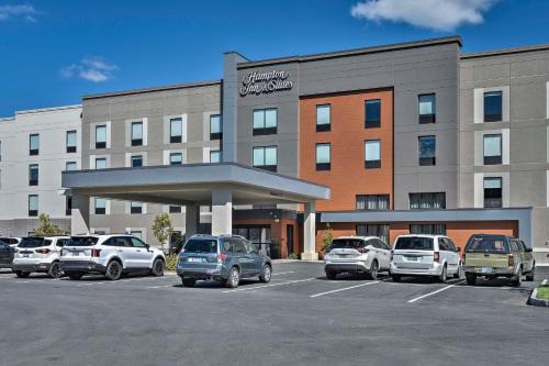 a parking lot with cars parked in front of a hotel at Hampton Inn & Suites Keene in Keene