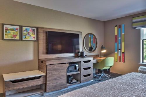 a bedroom with a tv and a desk with a chair at Hampton Inn & Suites Keene in Keene
