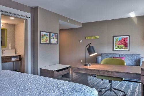 a hotel room with a desk and a bed at Hampton Inn & Suites Keene in Keene