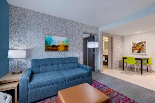 a living room with a blue couch and a table at Home2 Suites By Hilton Wilkes-Barre in Wilkes-Barre