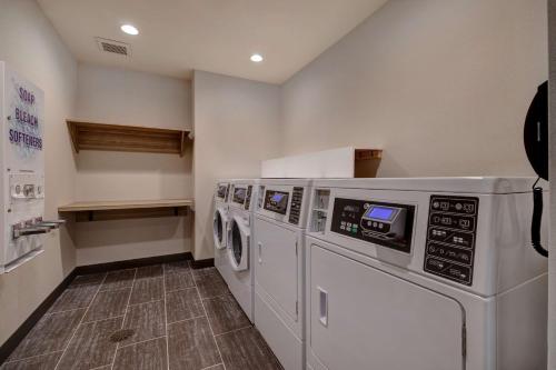 a laundry room with three washers and a dryer at Home2 Suites By Hilton Wilkes-Barre in Wilkes-Barre