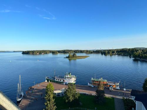 two boats are docked on a large lake at City Apartment Maaherrankatu in Kuopio