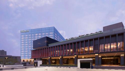 a building with a hilton sign on top of it at Hilton Bengaluru Embassy Manyata Business Park in Bengaluru