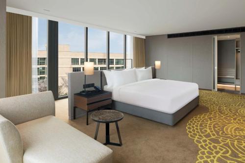 a hotel room with a bed and a couch and chairs at Hilton Bengaluru Embassy Manyata Business Park in Bengaluru