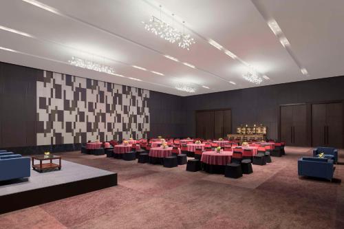 a large room with tables and chairs in it at Hilton Bengaluru Embassy Manyata Business Park in Bengaluru
