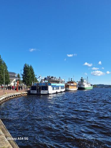 drei Boote, die an einem Dock auf dem Wasser angedockt sind in der Unterkunft City Apartment Maaherrankatu in Kuopio