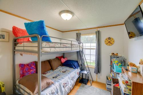 a bedroom with two bunk beds and a bed at Creekfront Max Meadows Mobile Home with Deck! in Max Meadows