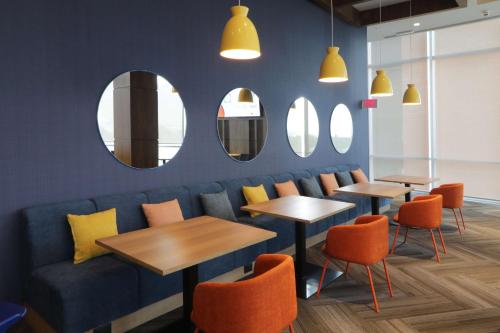 a restaurant with tables and chairs and mirrors at Tru By Hilton Monterrey Fundidora in Monterrey
