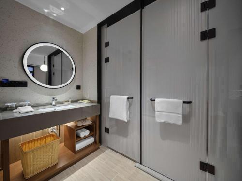 a bathroom with a sink and a mirror at Hilton Garden Inn Jincheng Gushuyuan in Jingcheng