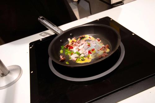 a pan on top of a stove in a kitchen at Embassy Suites By Hilton Alpharetta Halcyon in Alpharetta