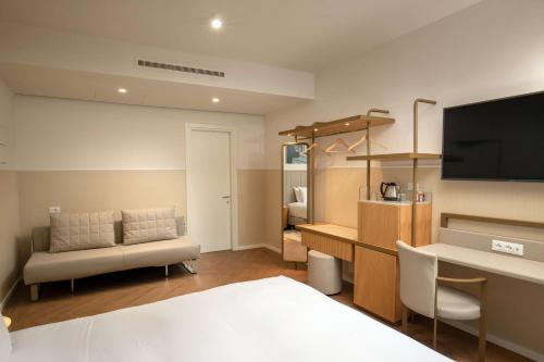 Cette chambre comprend un lit, un bureau et une télévision. dans l'établissement Cosmopolita Hotel Rome, Tapestry Collection by Hilton, à Rome