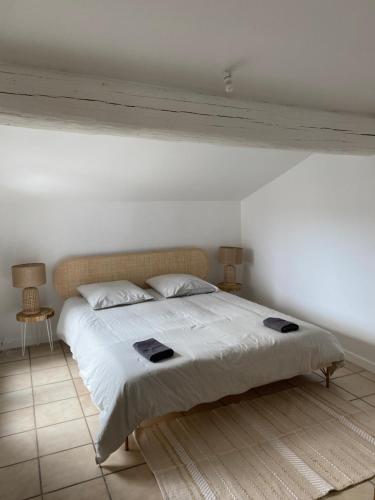 une chambre avec un grand lit avec des draps blancs dans l'établissement Duplex de charme avec terrasses, à Nîmes