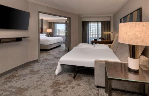 a hotel room with two beds and a flat screen tv at Embassy Suites by Hilton Bethesda Washington DC in Bethesda