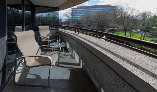 two chairs sitting on a balcony of a building at Embassy Suites by Hilton Bethesda Washington DC in Bethesda
