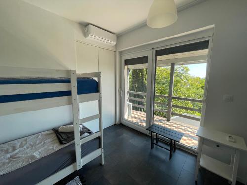 a bedroom with two bunk beds and a balcony at Rózsakő Nyaraló in Badacsonytomaj