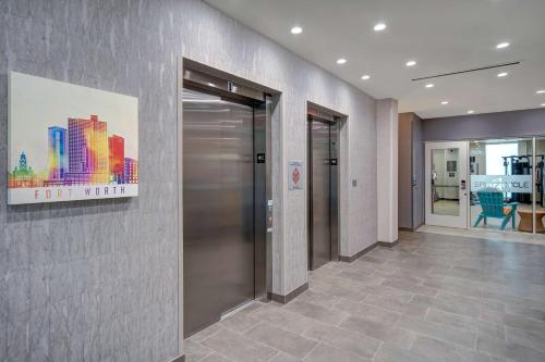 a hallway with a elevator in a building at Home2 Suites By Hilton Burleson in Burleson
