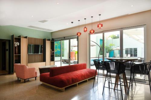 a living room with a red couch and a table at Hampton by Hilton Veracruz Boca Del Rio in Veracruz