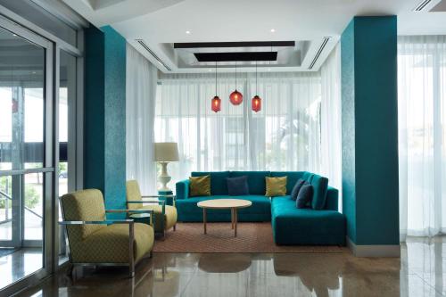 ein Wohnzimmer mit einem blauen Sofa und einem Tisch in der Unterkunft Hampton by Hilton Veracruz Boca Del Rio in Veracruz