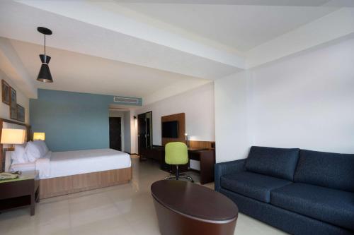 a hotel room with a bed and a couch at Hampton by Hilton Veracruz Boca Del Rio in Veracruz