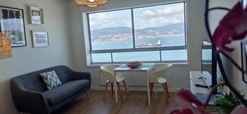 a living room with a table and a chair and a window at Impresionantes vistas en el centro de Vigo in Vigo