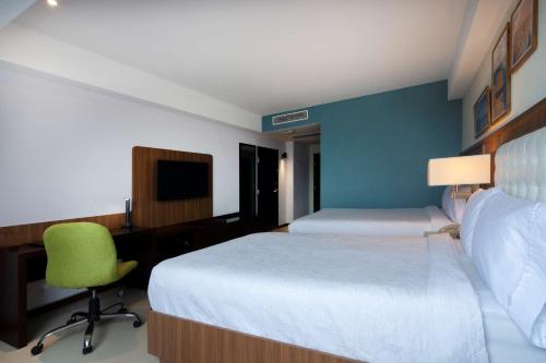 a hotel room with a bed and a desk and a chair at Hampton by Hilton Veracruz Boca Del Rio in Veracruz