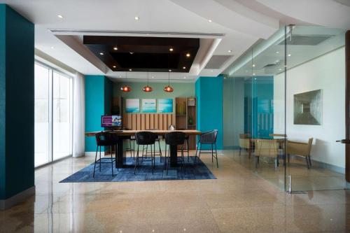 a dining room with blue walls and a table and chairs at Hampton by Hilton Veracruz Boca Del Rio in Veracruz